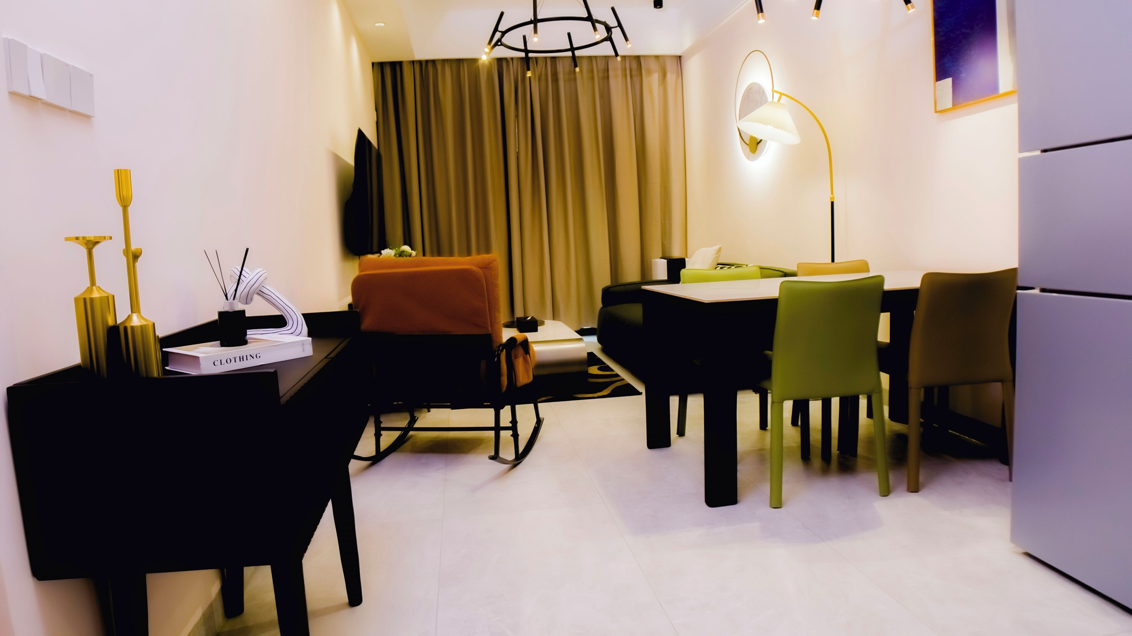 Een moderne eetruimte met een tafel, stoelen, een bank en een koelkast.