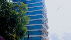 A multi-story building with a modern architectural design, featuring a prominent 'GREENLAND' sign at the top.