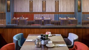 A restaurant with a modern interior, featuring a central dining area with tables and chairs, a wooden floor, and a ceiling with a skylight. - 2 Person Holiday Park Home in Sulzbach (Sulzbach)