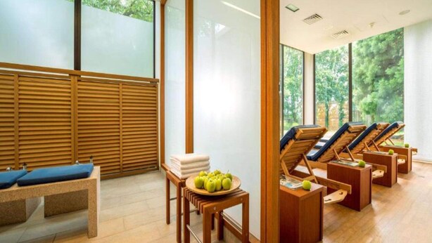 A spa room with wooden furniture, a table with apples, and a view of trees through large windows. - 2 Person Holiday Park Home in Sulzbach (Sulzbach)