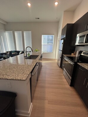 A modern kitchen with granite countertops, stainless steel appliances, and a central island.