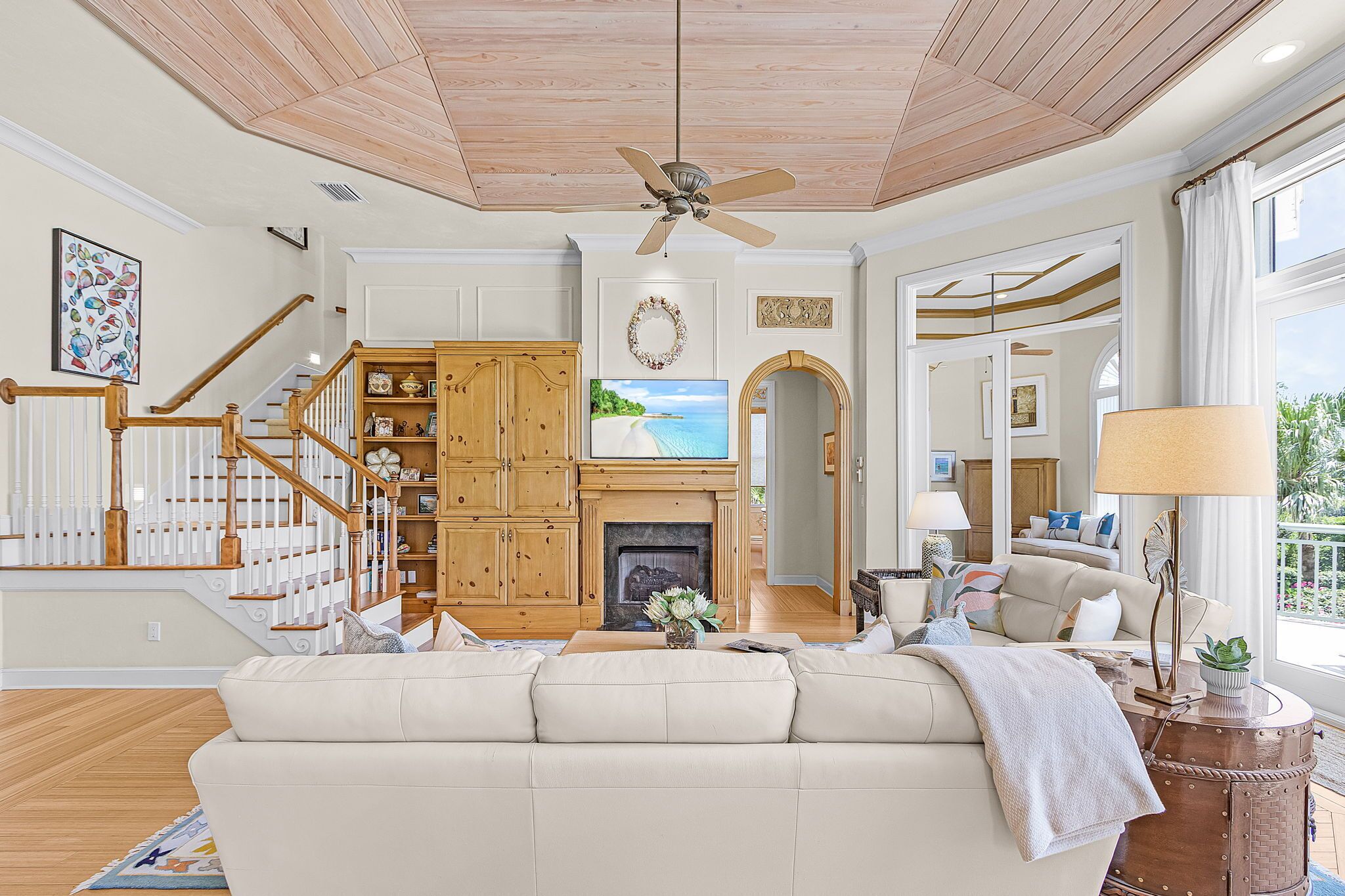 A living room with a fireplace, television, and a staircase.