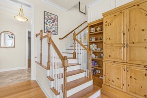 A staircase with wooden railings and white balusters, leading to a landing with a white-framed mirror and a wall-mounted picture. - 5 Bedroom / 5 Bath Luxury Estate (Captiva)