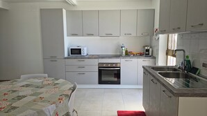 Una cocina compacta equipada con microondas, horno y lavamanos.