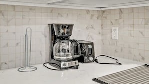 A kitchen with white cabinets, a coffee maker, and a glass carafe. - New 2-bedroom Garden apartment in peaceful Brooklyn with AC and charm (Brooklyn)