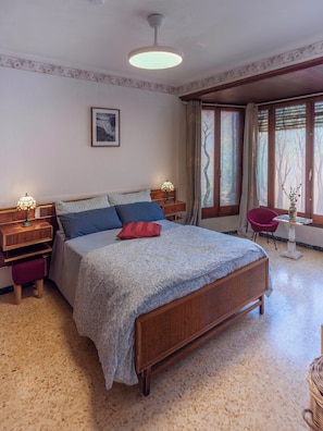 A bedroom with a bed, bedside tables, a chair, a window with curtains, and a ceiling light. - Your home in the Ebro Delta. Perfect for FAMILIES!! (L'Aldea)