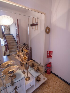 A hallway with a glass display table, a fire extinguisher, and a staircase. - Your home in the Ebro Delta. Perfect for FAMILIES!! (L'Aldea)
