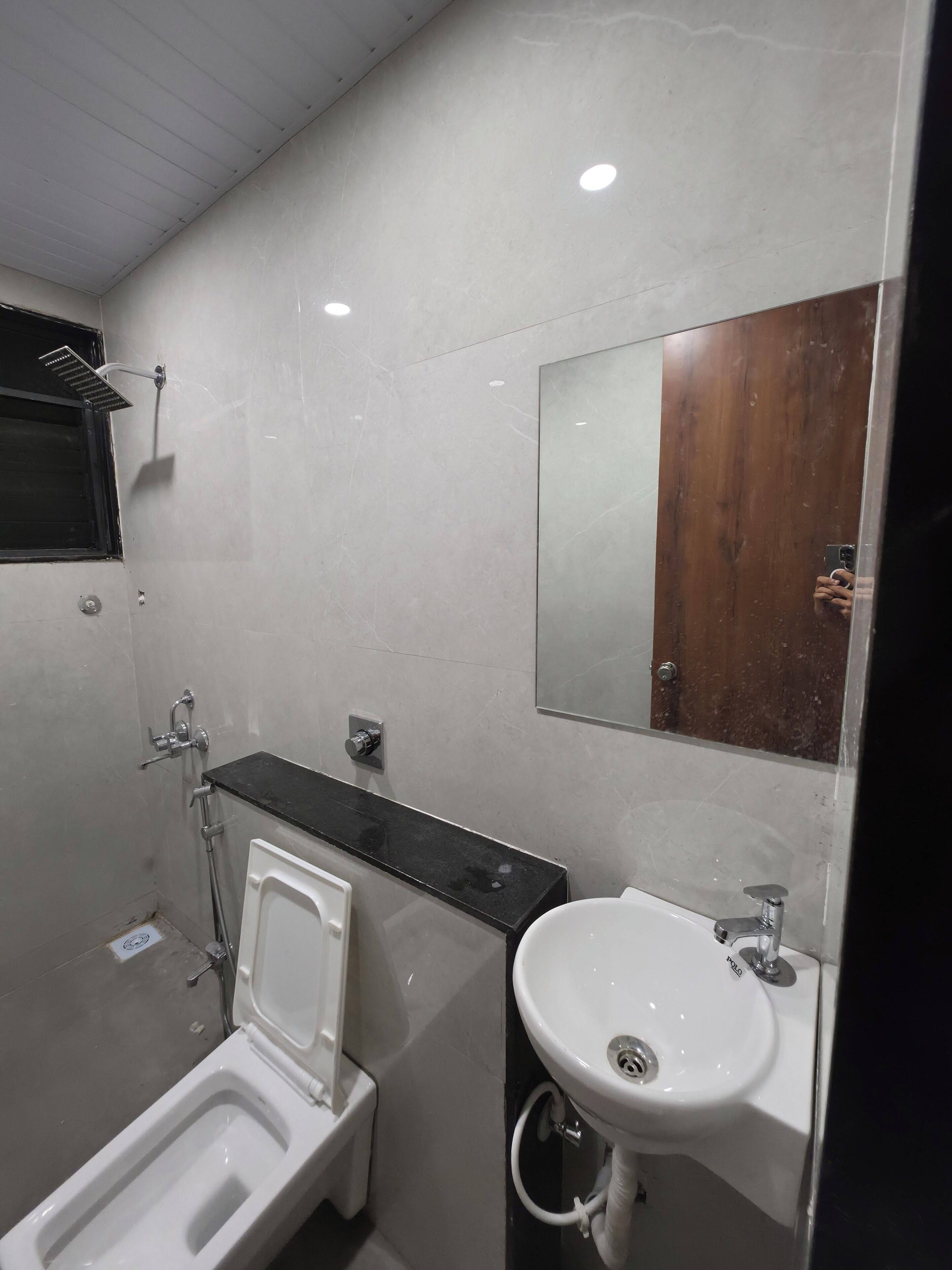 Un baño moderno con inodoro, bidé, lavamanos y espejo.