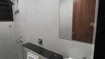 Un baño moderno con inodoro, bidé, lavamanos y espejo.
