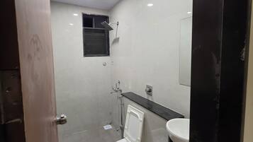 A small, modern bathroom with a toilet, sink, and shower.