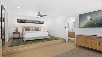 A modern bedroom with a bed, a ceiling fan, a TV, and a large window.