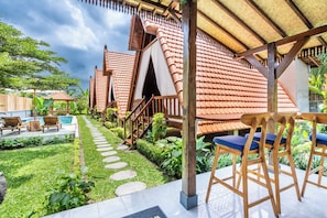 Ein traditionelles Haus mit Ziegeldach, Schwimmbad und Garten mit trittfesten Steinen.