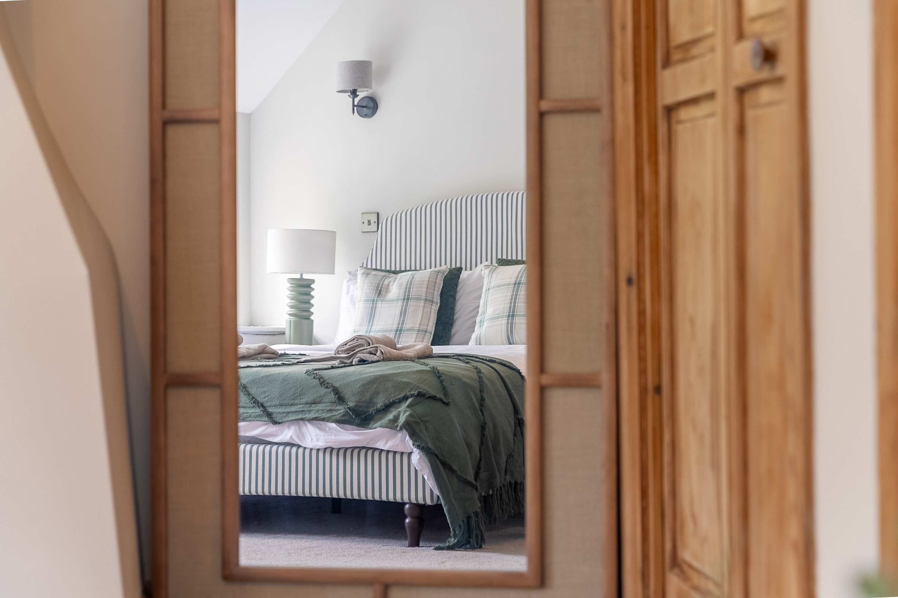 Un dormitorio con cama, una mesita de noche con lámpara y una lámpara de pared.