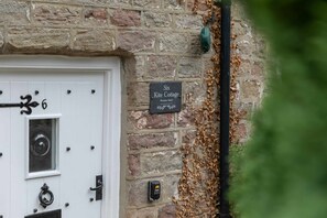 A white door with a number '6' and a black security device on a stone wall. - NEW Cosy Stone Cottage With Free Parking Wifi (Knaresborough)