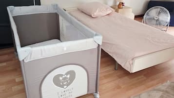 Una cama litera infantil con dosel, una mesita de noche pequeña con lámpara y un reloj decorativo.