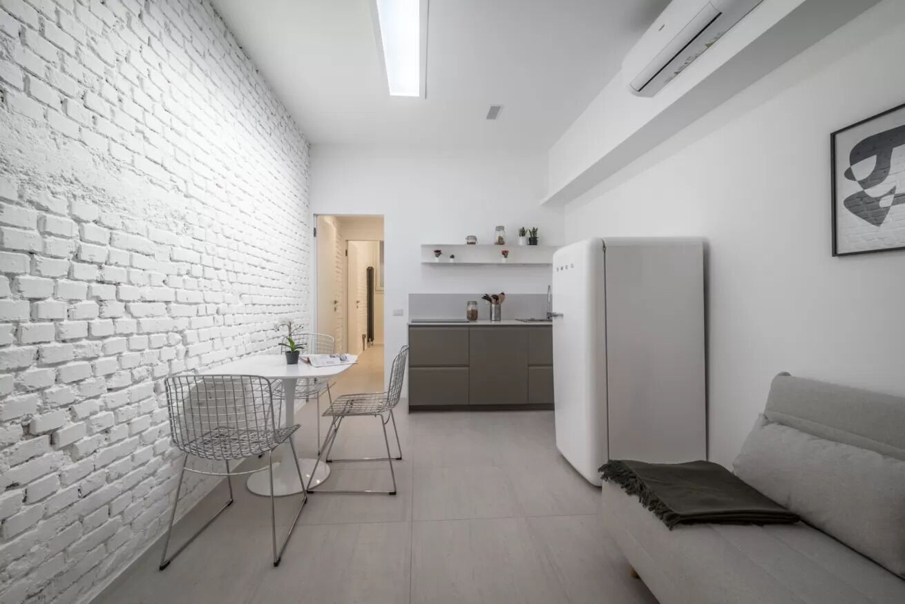 Une cuisine moderne avec des meubles blancs, un four encastré et un plan de travail.