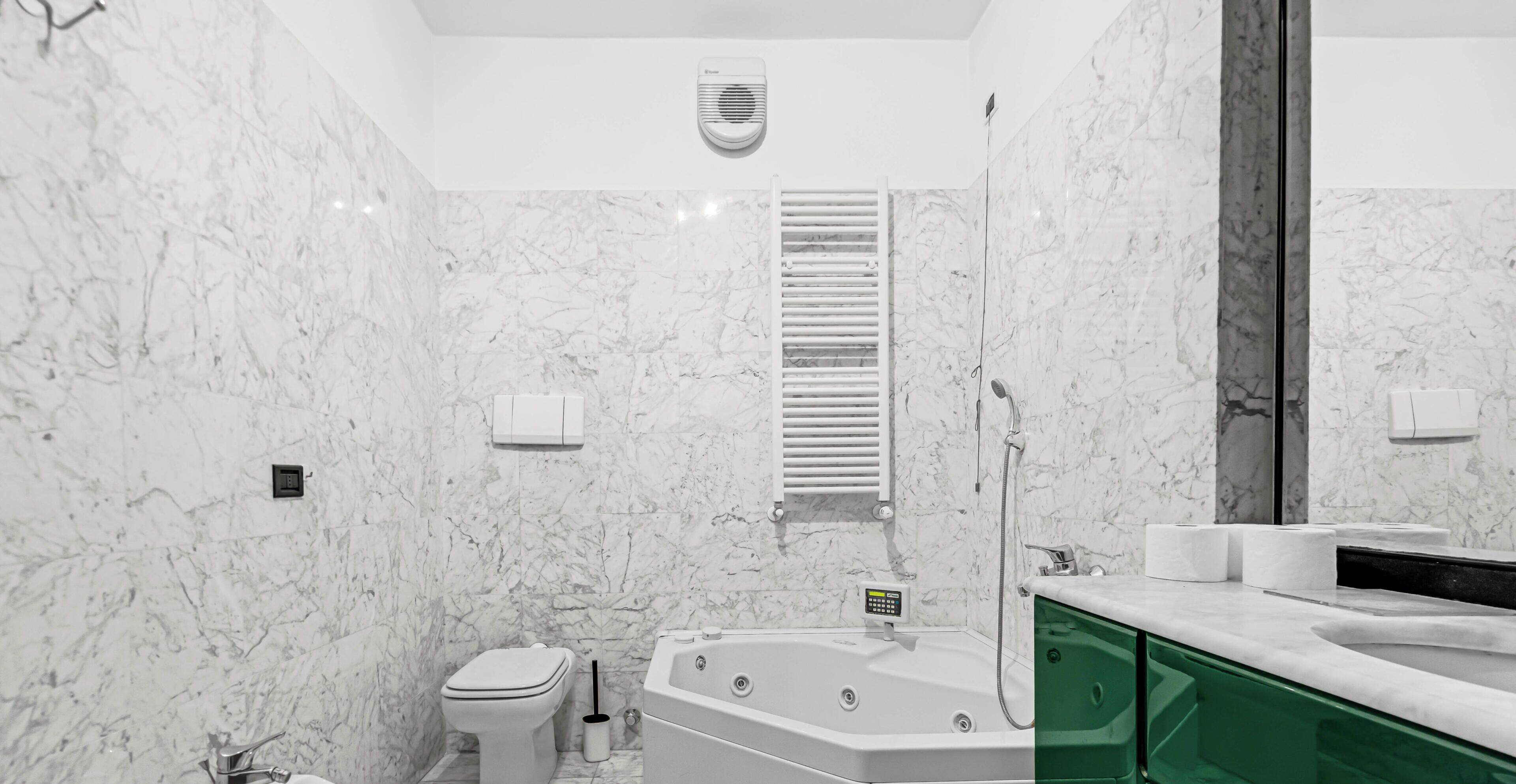 Ein modernes Badezimmer mit Toilette, Badewanne, Dusche und einem Waschtisch mit Spiegel.