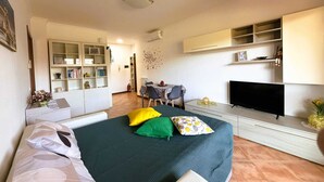 Ein Schlafzimmer mit einem Bett, einem Fernseher, einem Schreibtisch und einem Bücherregal.