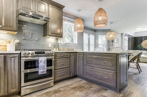 Una cocina moderna con electrodomésticos de acero inoxidable, armarios de madera oscura y una isla grande.