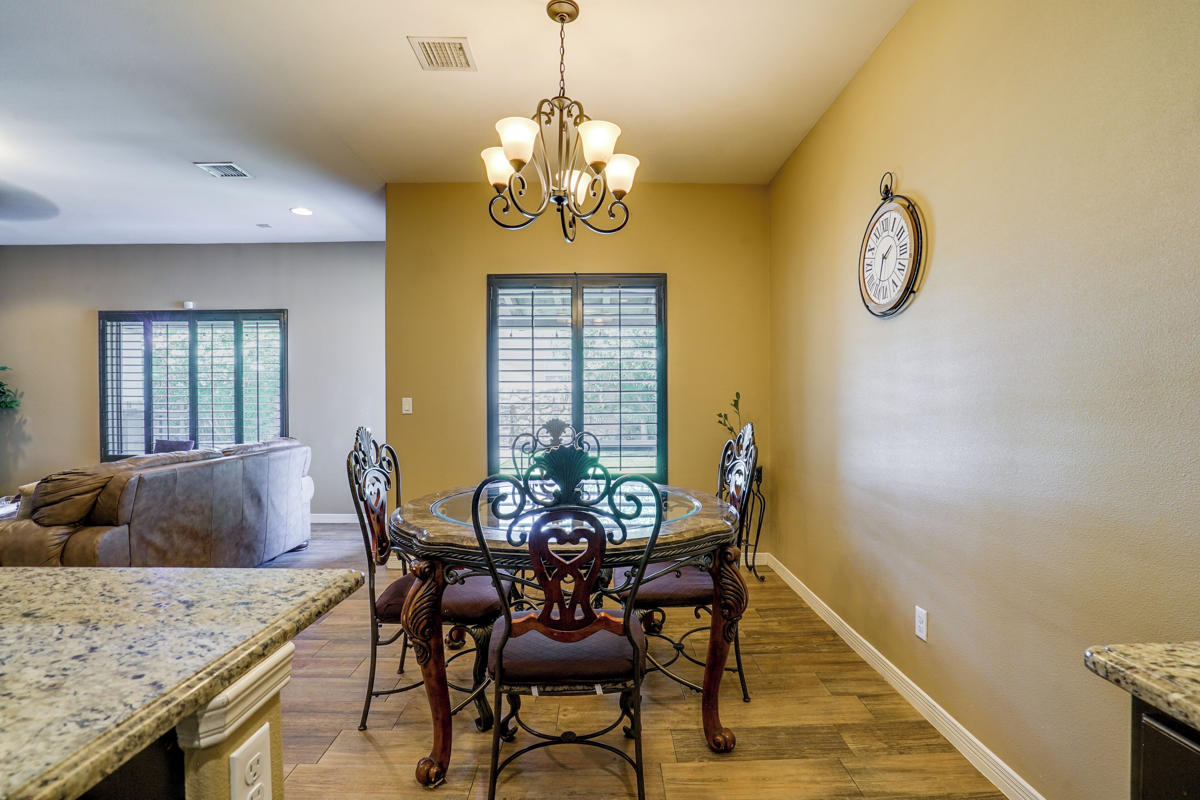 A dining area with a round table, chairs, and a chandelier.
