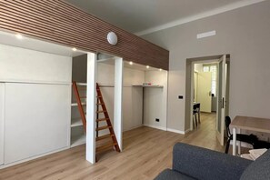 Ein modernes Interieur mit einem Loft-Zimmer, Holzböden, einer Treppe und einem Essbereich.
