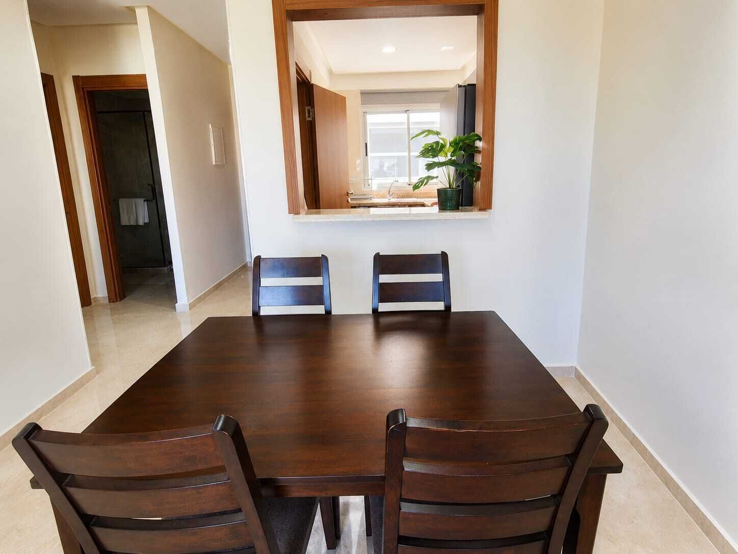 A dining area with a rectangular table and four chairs.