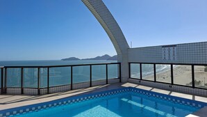A swimming pool with a view of the ocean and beach. - SHB Beachfront Varanda e Piscina (Santos)