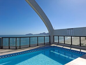 A swimming pool with a view of the ocean and beach. - SHB Beachfront Varanda e Piscina (Santos)