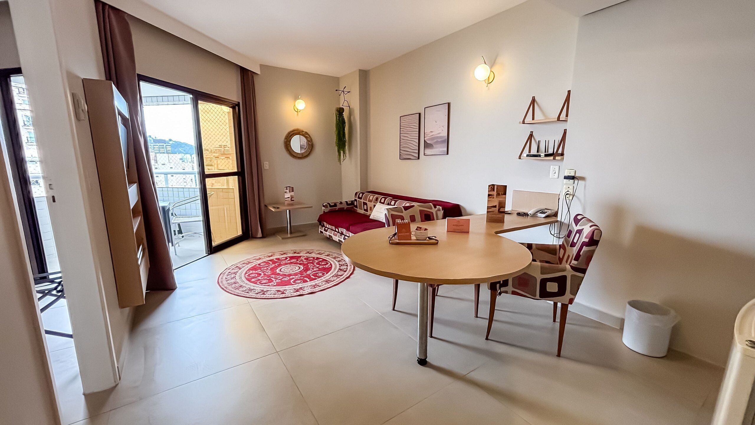 Una sala de estar moderna con una mesa redonda, sofá y vista a través de un ventanal.