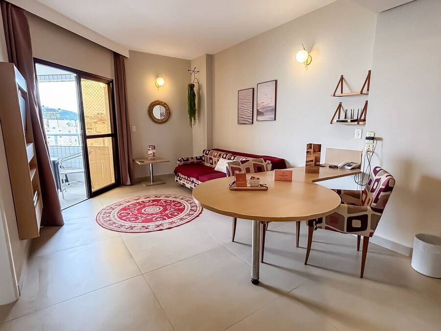 Una sala de estar moderna con una mesa redonda, sofá y vista a través de un ventanal.