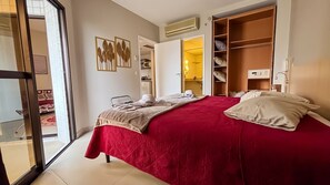A hotel room with a bed, a wardrobe, a bathroom, and a sliding glass door leading to a balcony. - SHB Beachfront Varanda e Piscina (Santos)