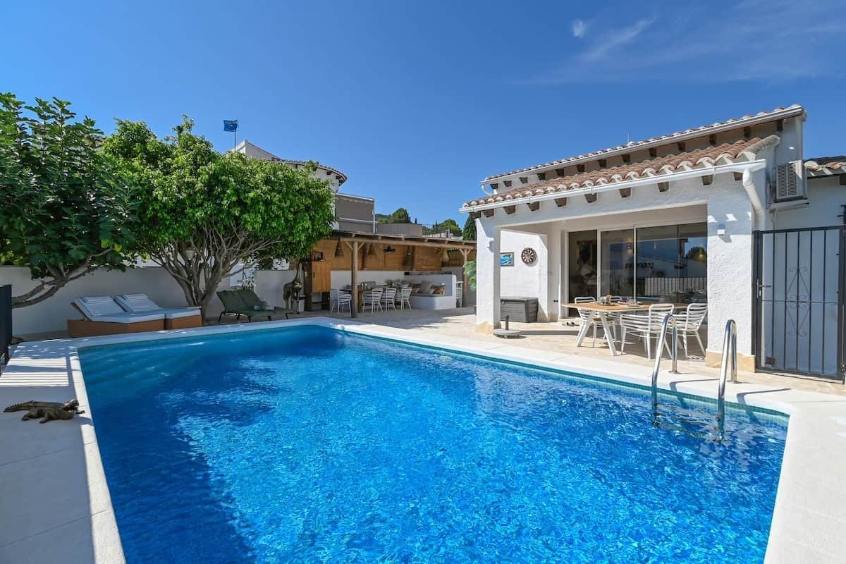 Una piscina con un lettino e una zona patio coperta.