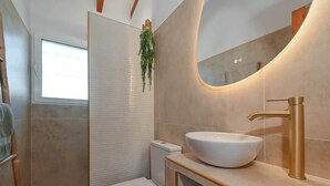 A modern bathroom with a white sink, gold faucet, and a large mirror. - Boho Villa Montsalvat (Pego)