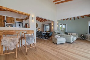 A spacious living area with a dining table, chairs, and a sofa. - Ibiza-Style Villa with Pool, Outdoor Kitchen, and King-Size Beds (Pego)