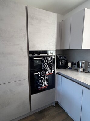A kitchen with a built-in oven, a coffee maker, and a kettle on the countertop. - Lovely 3-bedroom house in tranquil London perfect for your stay -sleeps 6 (London)