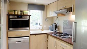 A compact kitchen with a built-in oven, a dishwasher, a gas stove, and a refrigerator. - Cottage in a Natural Domain P10 (Saint-Privat-de-Champclos)
