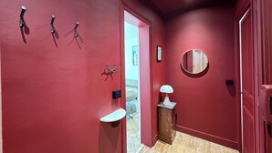 A hallway with red walls, a wooden floor, a round mirror, and a small table with a lamp. - Belle Époque Villa - La Batelière - Bow Window - Ocean View - Exceptional (Mers-les-Bains)