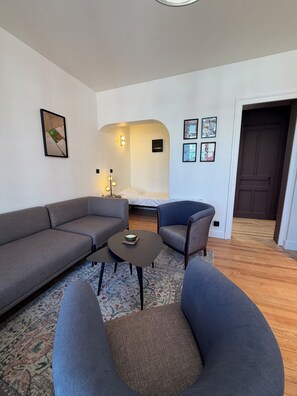 A modern living room with a sofa, armchair, coffee table, and a rug. - VILLA BELLA - BELLE ÉPOQUE - BALCONY WITH OCEAN VIEW - EXCEPTIONAL - 20 METERS FROM THE BEACH (Mers-les-Bains)