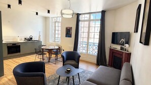 En moderne stue med sofa, stole, et lille bord og et spiseområde med stole og bord.