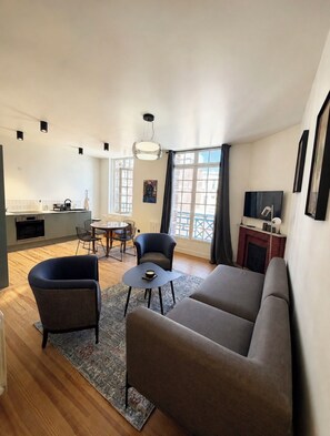 A modern living room with a sofa, chairs, a small table, and a dining area with chairs and a table. - VILLA BELLA - BELLE ÉPOQUE - BALCONY WITH OCEAN VIEW - EXCEPTIONAL - 20 METERS FROM THE BEACH (Mers-les-Bains)