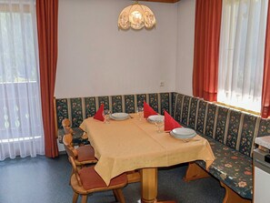 Un comedor con mesa, sillas, banco e iluminación instalada en la pared.