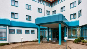 A modern building with a circular brick courtyard, blue accents on the facade, and a covered entrance area. - 1 Person Holiday Park Home in Herrenberg (Herrenberg)