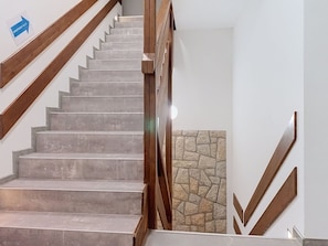 Eine Treppe mit hölzernen Geländern und einem Schild, das eine Wohnung anzeigt.