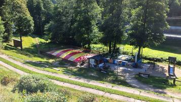 En campingplads med et stort telt, picnicborde og en lille hytte.