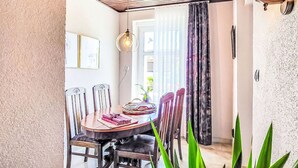 Un espace repas comprenant une table ronde, des chaises et un luminaire suspendu.