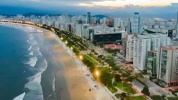 Un paisaje urbano costero con una playa, edificios altos y un cielo despejado.