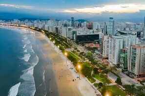 Un paysage urbain côtier avec une plage, des immeubles de grande hauteur et un ciel dégagé.