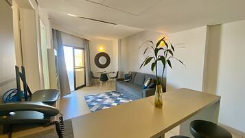Una sala de estar moderna con un sofá, una mesa de comedor y una planta grande.