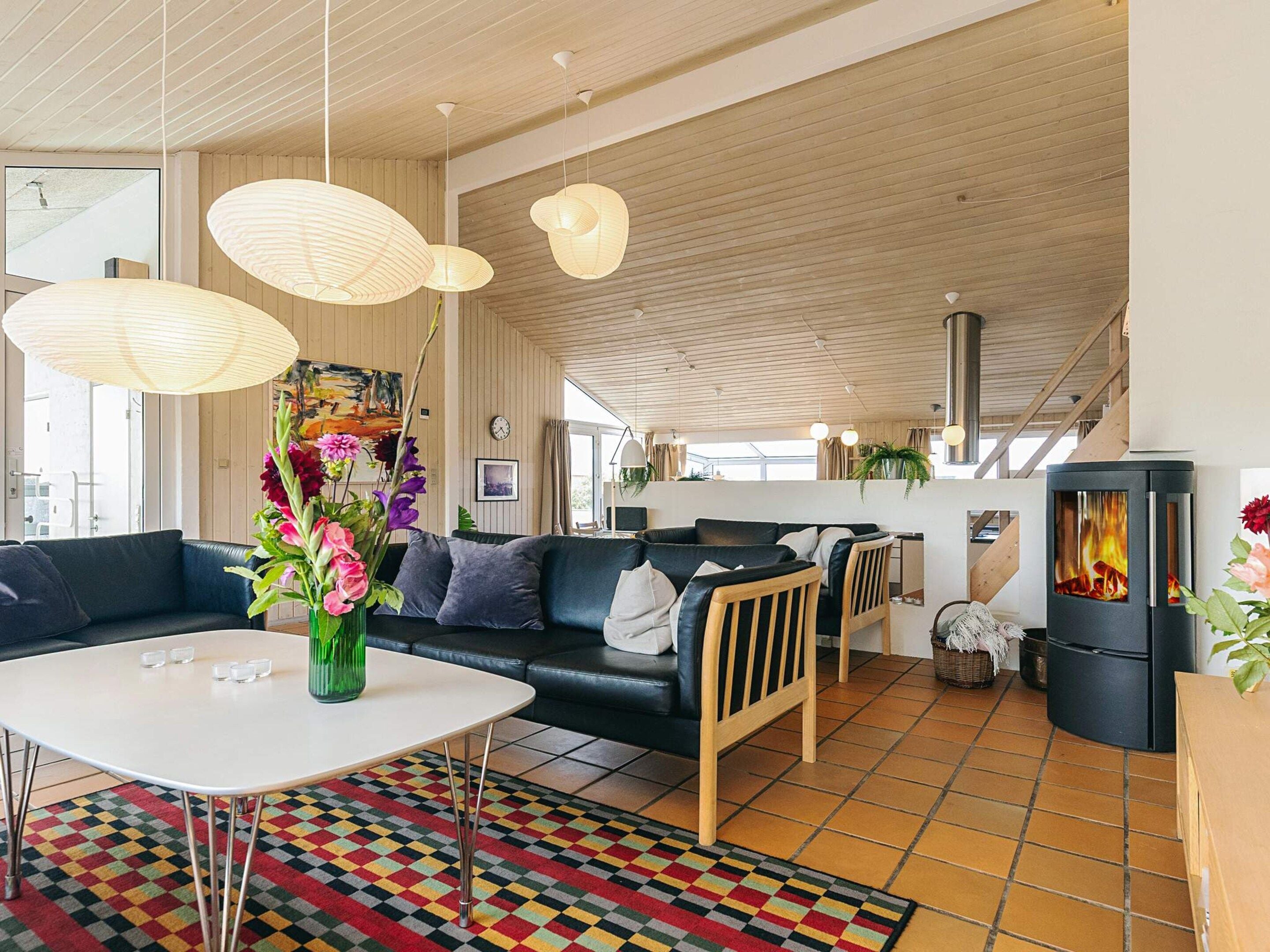 Una sala de estar moderna con un sofá, una mesa de centro y una chimenea.