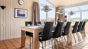 Ein Essbereich mit einem Holztisch, Stühlen, einer Uhr und einem gerahmten Bild an der Wand.